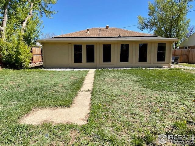 rear view of property featuring a lawn