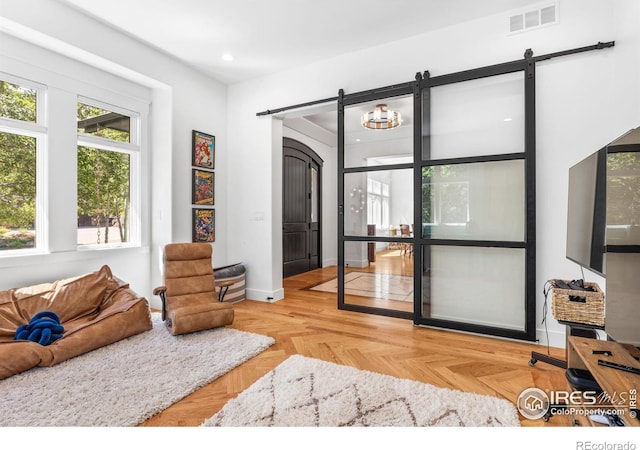 living room with light parquet flooring and a barn door