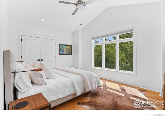 bedroom featuring hardwood / wood-style flooring, a closet, vaulted ceiling, and ceiling fan