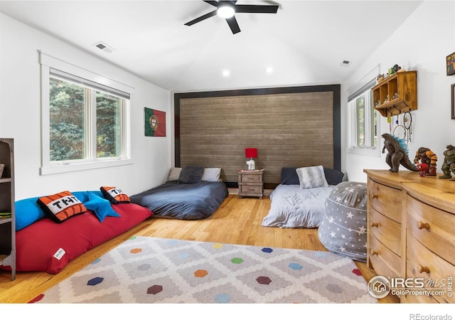 bedroom with ceiling fan, hardwood / wood-style floors, and lofted ceiling