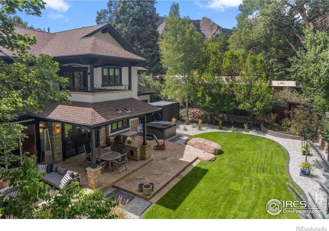 view of yard with a balcony, a hot tub, a mountain view, a patio area, and an outdoor hangout area