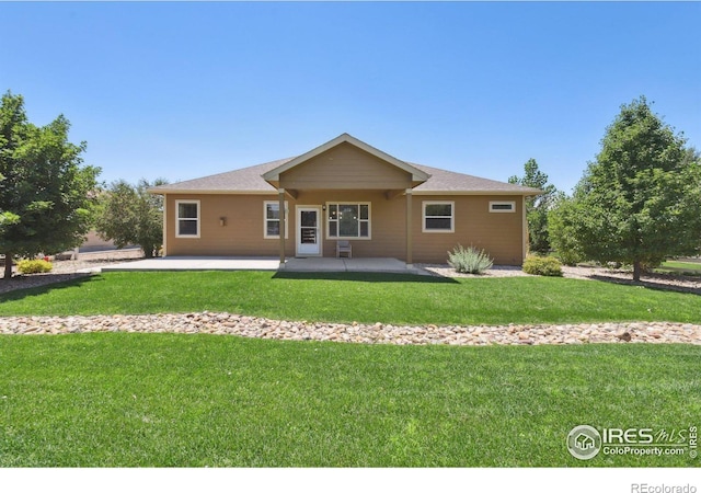 rear view of property with a yard and a patio