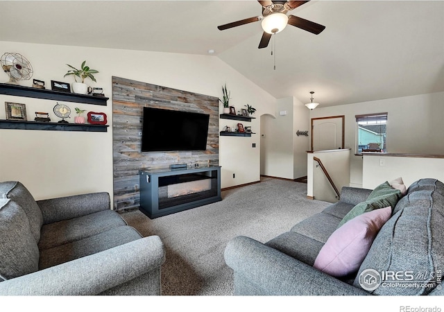 living room with carpet floors, a tile fireplace, lofted ceiling, and ceiling fan