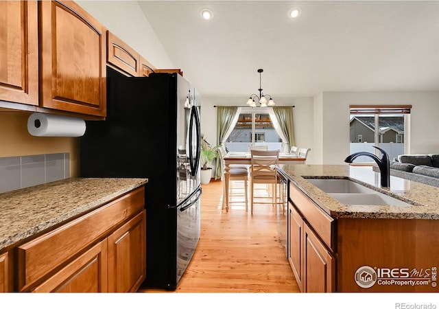 kitchen with sink, plenty of natural light, pendant lighting, and light hardwood / wood-style floors