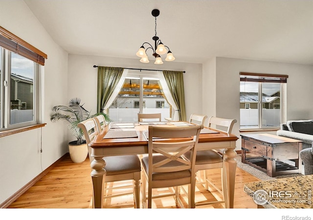 dining space featuring light hardwood / wood-style flooring and a notable chandelier