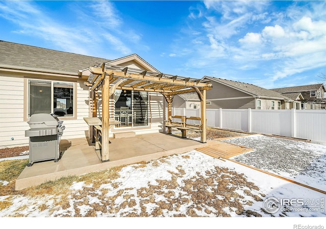 snow covered patio with a pergola and a grill