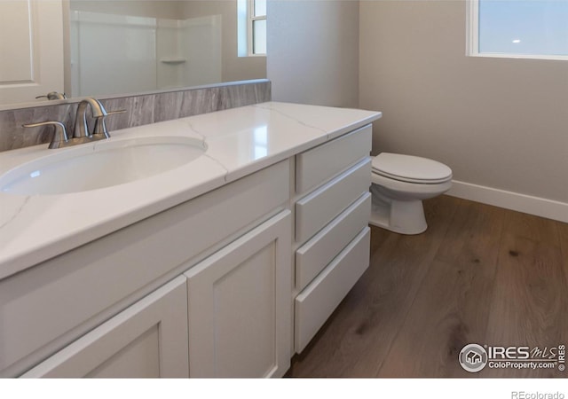 bathroom with vanity, toilet, and hardwood / wood-style floors