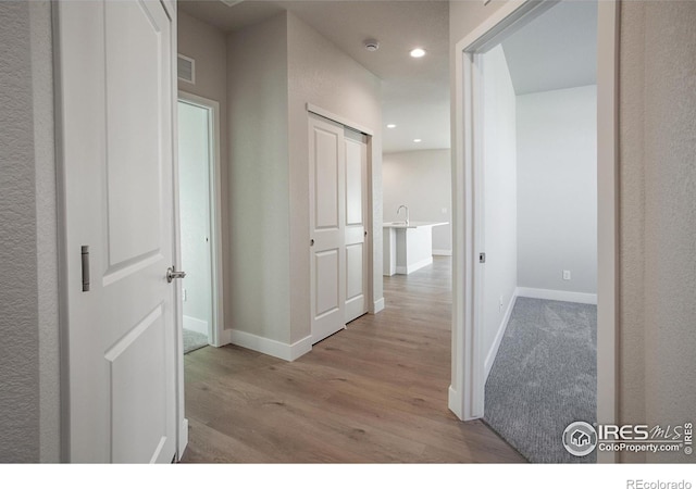 corridor with light hardwood / wood-style flooring