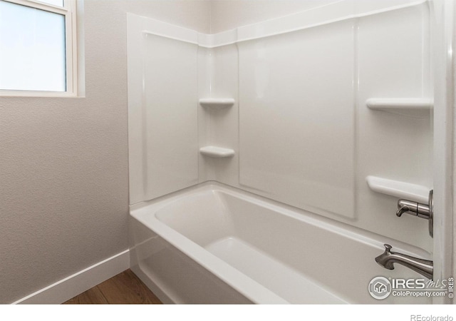 bathroom featuring hardwood / wood-style flooring and  shower combination