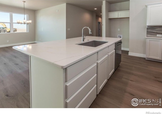 kitchen with an island with sink, pendant lighting, sink, and stainless steel dishwasher