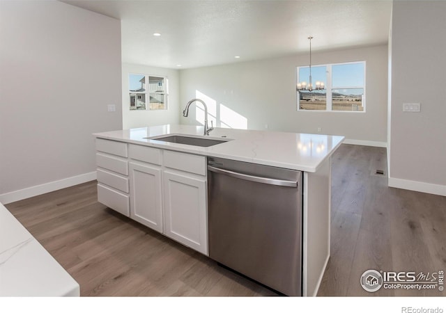 kitchen featuring sink, dishwasher, white cabinetry, a center island with sink, and decorative light fixtures