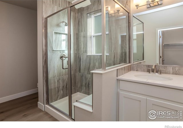 bathroom with hardwood / wood-style flooring, vanity, and walk in shower