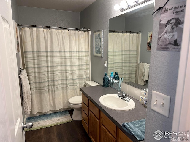 full bathroom featuring a textured ceiling, wood-type flooring, vanity, toilet, and shower / tub combo with curtain