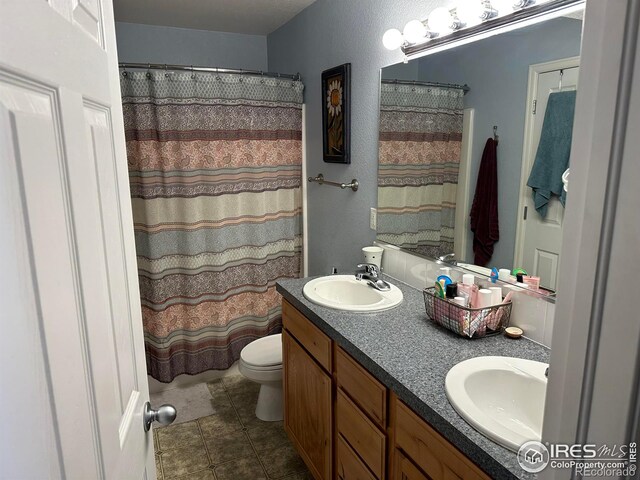 bathroom with curtained shower, toilet, and vanity