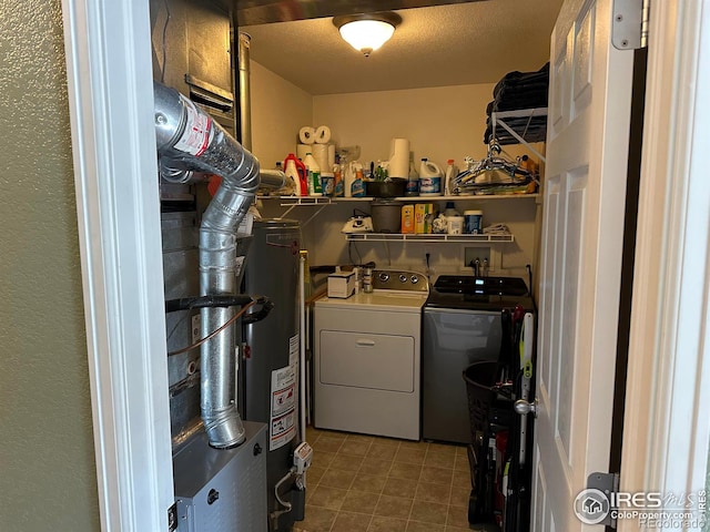 clothes washing area featuring gas water heater, separate washer and dryer, and a textured ceiling