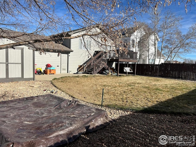 view of yard featuring a patio area, a deck, and a shed