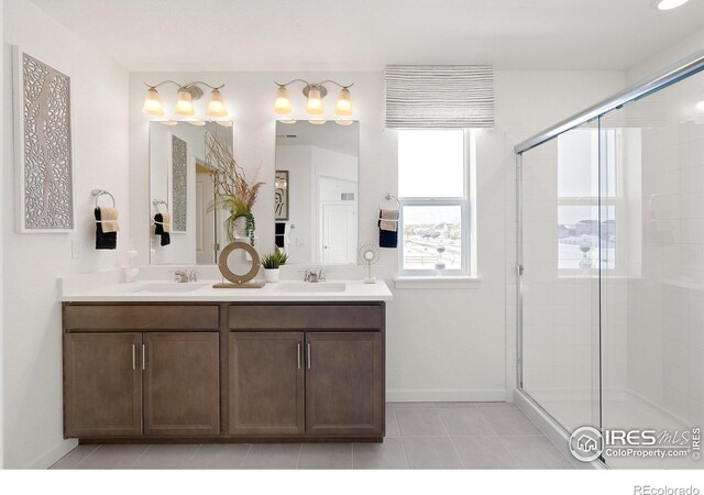 bathroom featuring a shower with shower door, tile patterned floors, and vanity