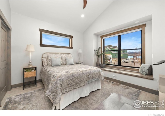 bedroom with hardwood / wood-style floors, a closet, and high vaulted ceiling