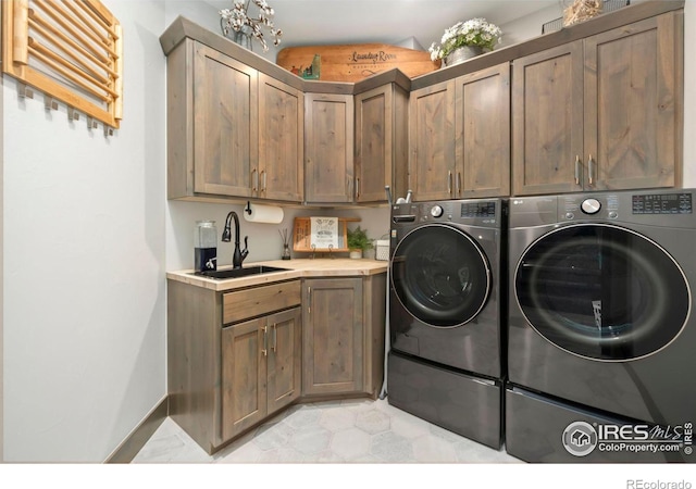 washroom featuring cabinets, sink, and washer and dryer