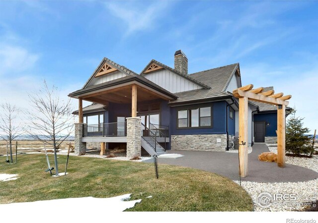 view of front of home with a front yard and a pergola