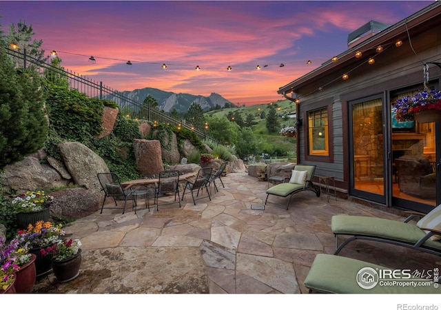 patio terrace at dusk featuring a mountain view