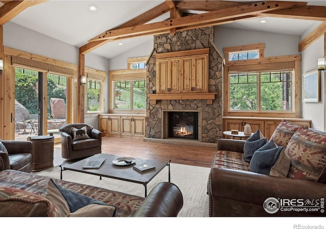 living room with hardwood / wood-style flooring, high vaulted ceiling, beamed ceiling, and a fireplace