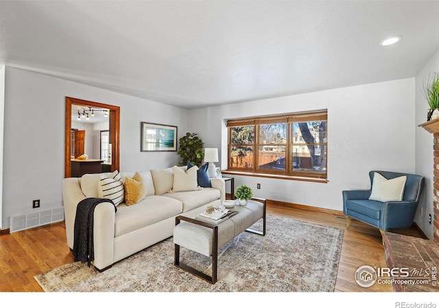 living room featuring a fireplace and light hardwood / wood-style flooring