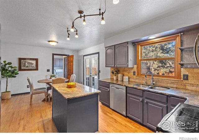 kitchen featuring french doors, stainless steel appliances, sink, and backsplash