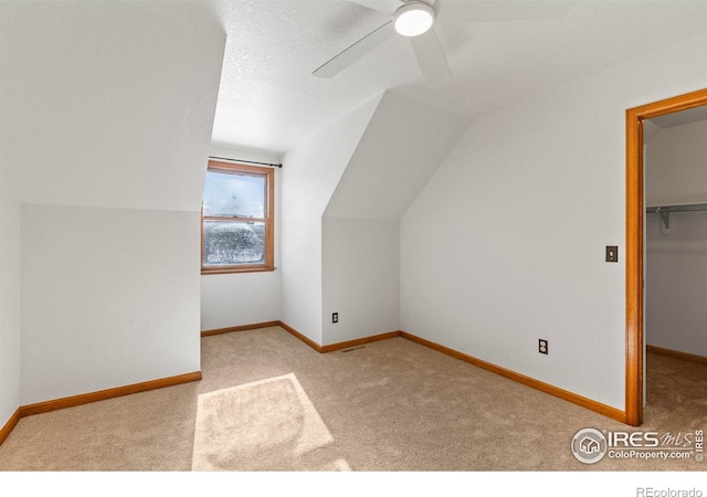 additional living space featuring vaulted ceiling, light colored carpet, and ceiling fan