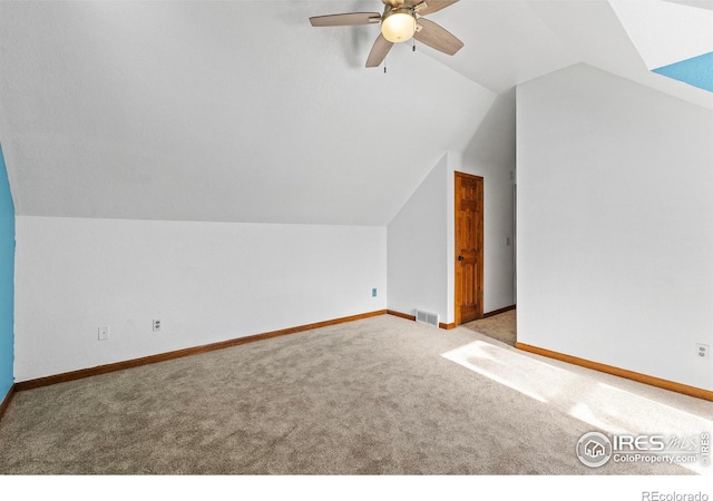 additional living space featuring vaulted ceiling, light colored carpet, and ceiling fan