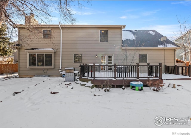 snow covered house with a deck