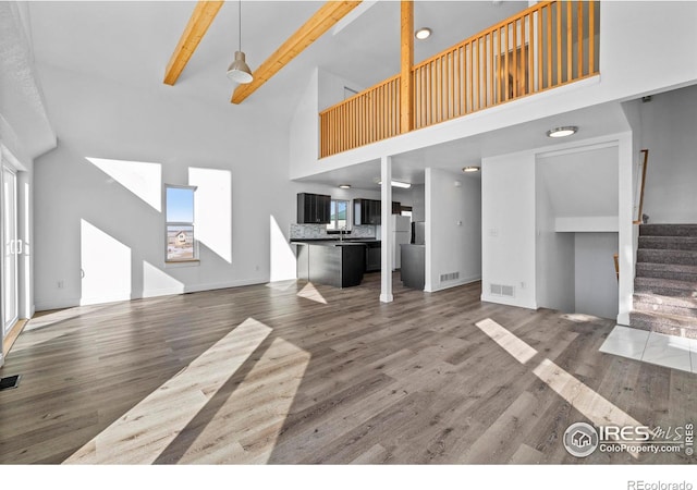 living room featuring high vaulted ceiling, beam ceiling, and hardwood / wood-style floors