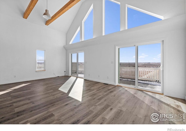 unfurnished living room with hardwood / wood-style flooring, beamed ceiling, and high vaulted ceiling