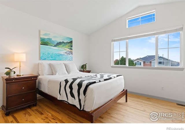 bedroom featuring light hardwood / wood-style flooring and vaulted ceiling