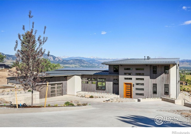 prairie-style home featuring a mountain view, a garage, and solar panels