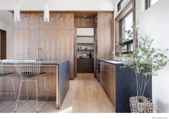 bar featuring sink and light hardwood / wood-style floors