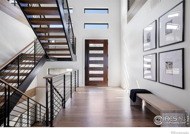 foyer entrance featuring a high ceiling and wood-type flooring