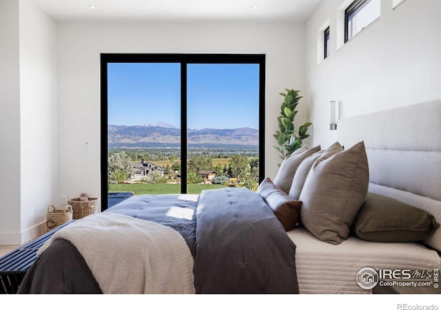 bedroom with a mountain view and wood-type flooring