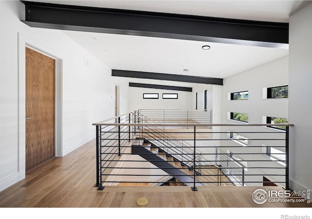 interior space featuring hardwood / wood-style flooring and lofted ceiling with beams