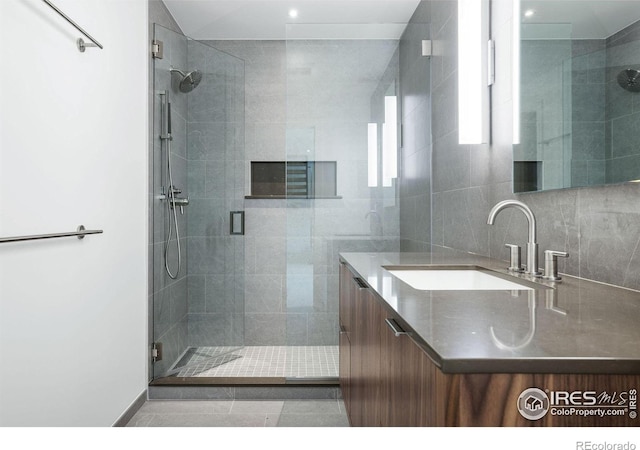 bathroom with vanity, decorative backsplash, and a shower with door