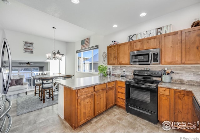 kitchen featuring pendant lighting, backsplash, kitchen peninsula, and appliances with stainless steel finishes