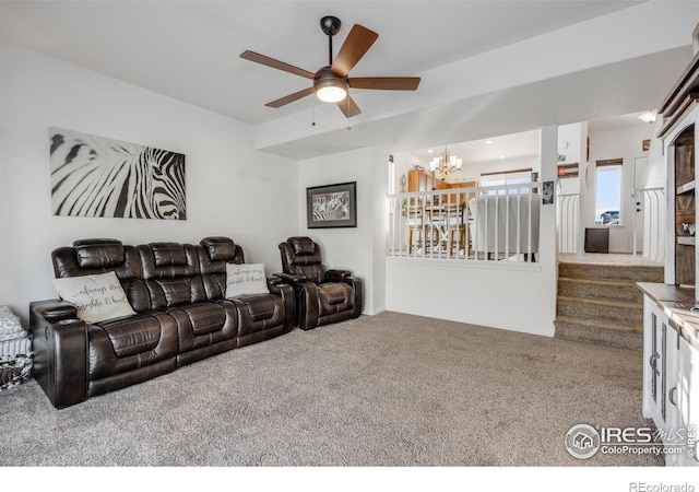 carpeted home theater with ceiling fan with notable chandelier