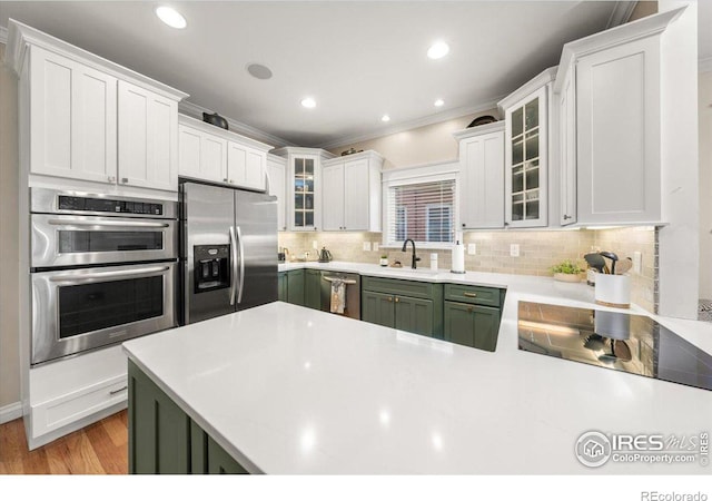 kitchen featuring sink, white cabinets, decorative backsplash, and stainless steel appliances