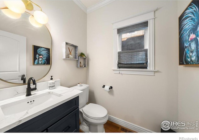 bathroom featuring toilet, vanity, and crown molding