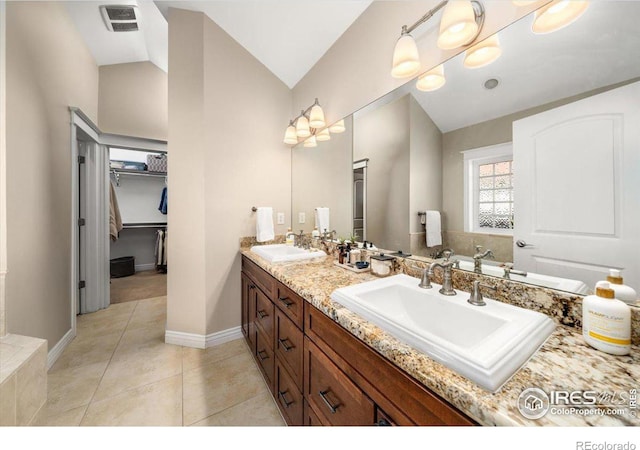 bathroom with tile patterned floors, lofted ceiling, and vanity