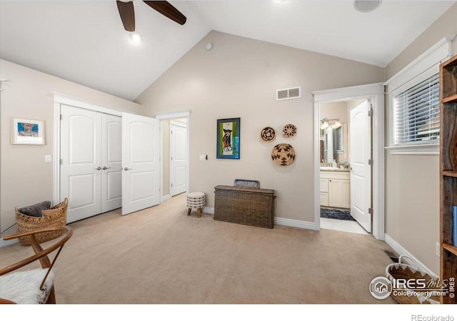 carpeted bedroom with a closet, ceiling fan, high vaulted ceiling, and connected bathroom