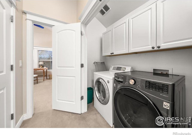 laundry room with cabinets, light colored carpet, and washing machine and clothes dryer