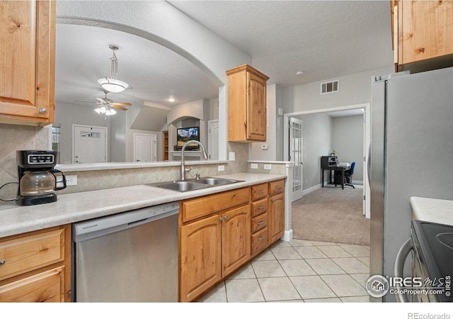 kitchen featuring stainless steel appliances, tasteful backsplash, sink, ceiling fan, and light colored carpet