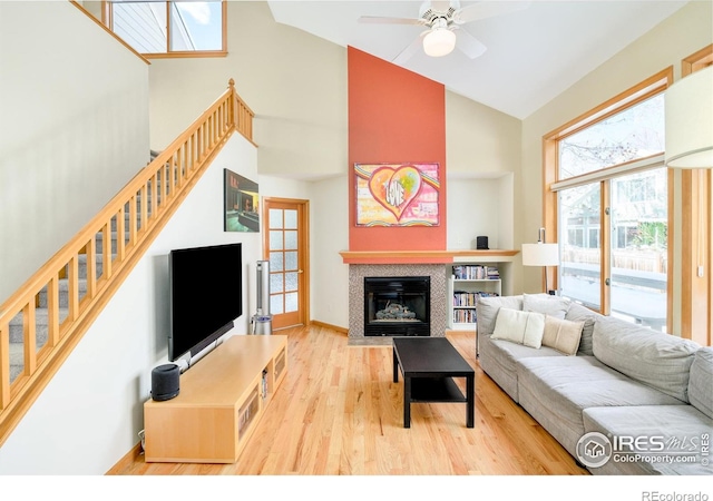 living room with light wood-type flooring, high vaulted ceiling, and ceiling fan