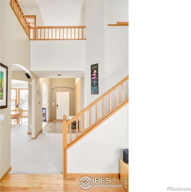 entryway with light hardwood / wood-style floors and a high ceiling